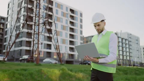 Male Engineer Standing Outside in Protective Gear Inspects Power Line Using Stock Footage 244905935