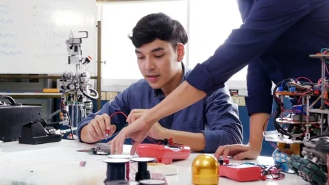 Male engineer training how to work with robotics prototype in workshop. Stock Footage 94258435