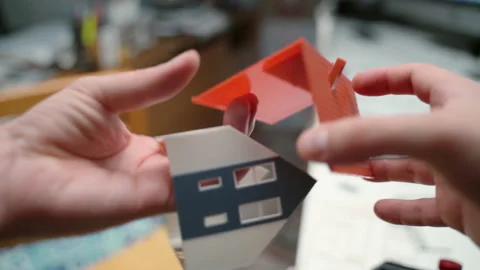 Male engineer using plastic and designer items for construction of masion model 스톡 동영상 136109783