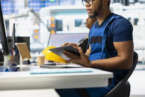 Male engineer using tablet to oversee solar panel assembly line 스톡 사진
