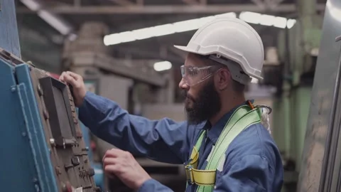 Male engineer walking and checking on big machine in the factory Stock Footage 194415458