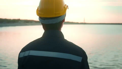 A male engineer wearing a protective helmet at sunset.. 스톡 동영상 167947692