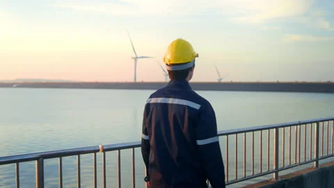 A male engineer wearing a protective helmet at sunset.. Video stock 167948342