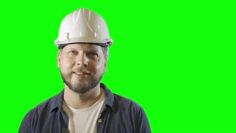 Male engineer worker in a construction helmet smiles on a green  background Vídeos de archivo 211129469