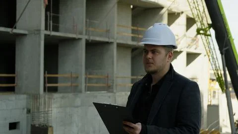 Male engineer working on a laptop at the active construction site Foto stock