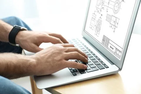Male engineer working with technical drawing on laptop at table, closeup Foto stock