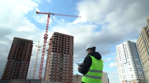 A male engineer works by inspecting work at a construction site Stock Footage 190472548