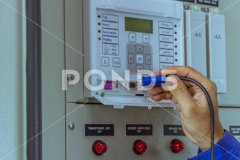 Male engineers are connect cable at equipment to laptop for check electrical Stock Photos