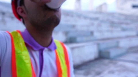 Male engineers are drinking coffee while working outside Stock Footage 107379574