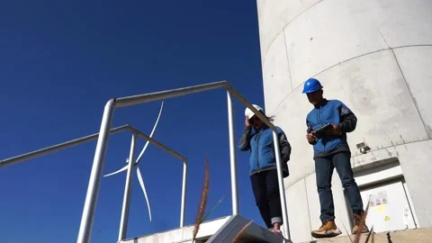 Male engineers are talking about wind turbine system technician woman Video stock 165941341