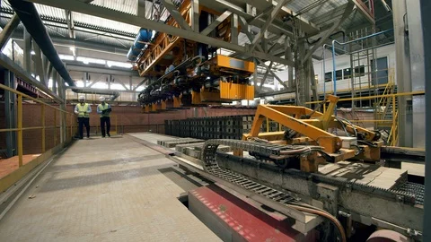 Male engineers check a machine while it works with bricks. Video stock 118656266