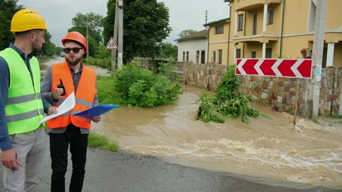 Male engineers solve flood problem. Devastation wrought after massive disasters Video stock 135386063