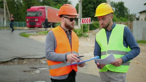 Male engineers solve flood problem. Devastation wrought after massive disasters Stock-Footage 135386836