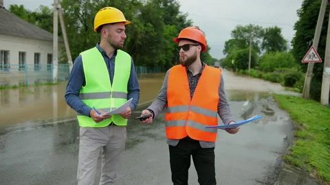 Male engineers solve flood problem. Devastation wrought after massive disasters Stock-Footage 135420823