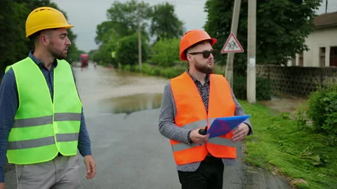 Male engineers solve flood problem. Devastation wrought after massive disasters Video stock 135431146