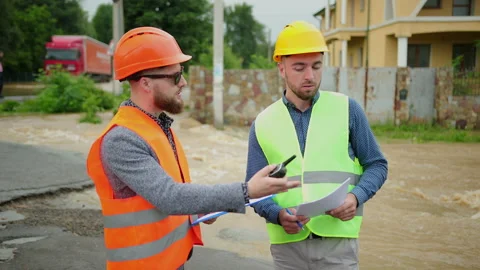 Male engineers solve flood problem. Devastation wrought after massive disasters Stock-Footage 135616948