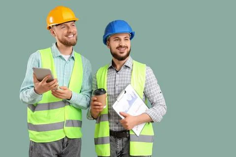 Male engineers with tablet computer and coffee on green background Stock Photos