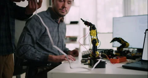 Male Engineers Wiring and Testing Robotic Arm Prototype. Stock Footage 306736722
