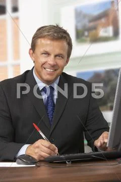 Male Estate Agent Working At Desk Stock Photos