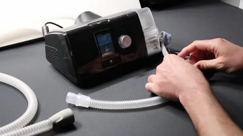 Male European with cpap machine checking therapy equipment like cpap filter Stock Footage 287975892
