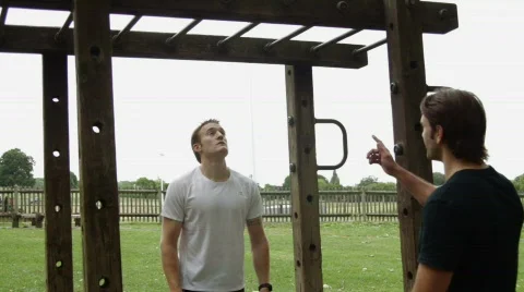 Male exercising on push pull stretch bar with personal trainer Stock Footage 783578