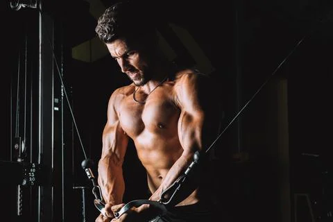 Male exercising with weights using a machine in a gymnasium Stock Photos