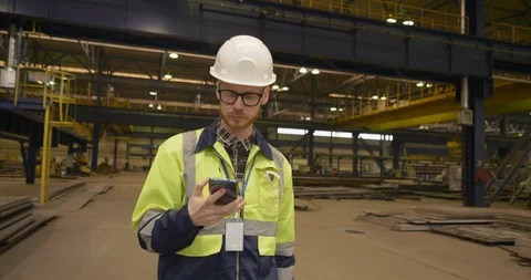 Male factory worker using mobile phone in factory Stock Footage 106568113