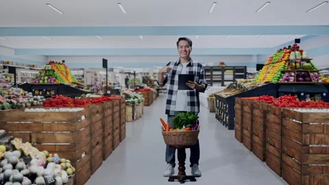 Male Farmer With Vegetable Basket Using And Pointing To Tablet in Grocery Store Stock Footage 311232453