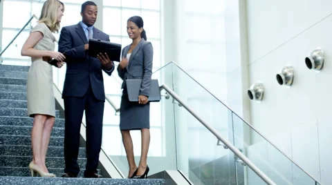 Male female multi ethnic financial business team in the office atrium Stock Footage