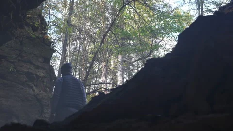 Male Figure in Rocky Cave Dramatic Natural Light Stock Footage 264670045