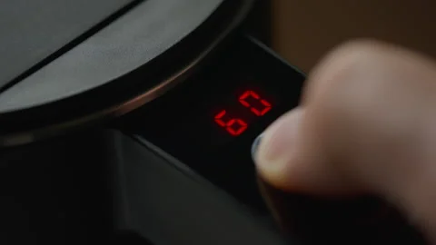 Male finger press the button selecting temperature on black electric kettle Stock Footage 258175659