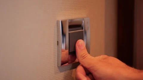 Male finger pressing light switch on wall in modern hotel room or home interior. Stock Footage 336724560