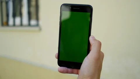 Male finger using smartphone with vertical green mock-up screen and doing swipin Stock Footage 112354918