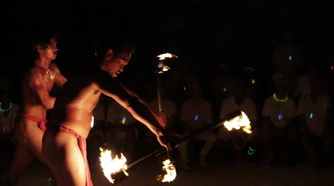 Male fire dancer creates 2 spinning fire rings then finishes performance Video stock 68101156