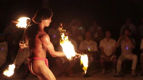 Male fire dancer juggles 2 spinning fire rings at once, throws and catches one Vidéo 68101343