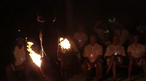 Male fire dancer juggles fire, switches hands and throws and catches flame Vidéo 68100520