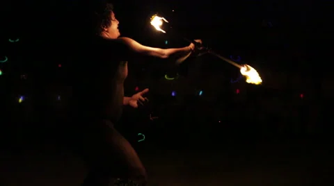 Male fire dancer performs elaborate juggling with one fire ring, throws into air Vidéo 68101244