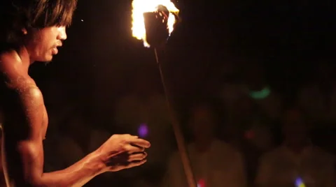 Male fire dancer throws two spinning fire rings then stops - Close Up Video stock 68101290