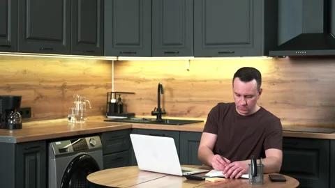 Male freelancer brainstorming while sitting at kitchen table. Stock Footage 301655480