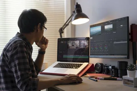 Male freelancer editing video on computer with professional program in home.. Stock Photos