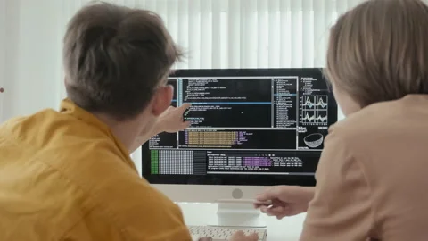 Male Friends Discussing Program Codes on Computer Monitor Stock Footage 231478700