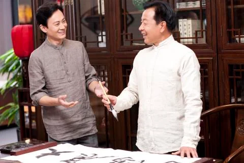 Male friends practicing calligraphy in the study Stock Photos