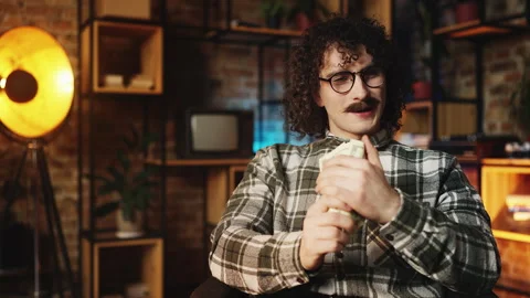 Male game developer in 90s counting money in office, celebrating high income Stock Footage 315456632