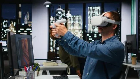 Male game developer using VR glasses and AI tech to design a spaceship 库存照片