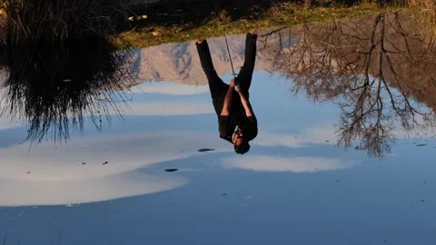 Male Golfer Reflected Upside Down in a Water Pond and Hitting the Golf Ball Stock Footage 269893840