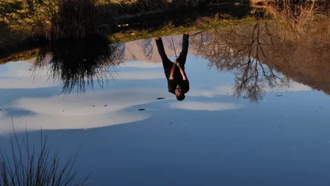 Male Golfer Reflected Upside Down in a Water Pond and Hitting the Golf Ball Stock Footage 272762345