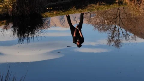 Male Golfer Reflected Upside Down in a Water Pond and Hitting the Golf Ball Stockbeeldmateriaal 274070868