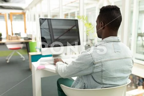 Male graphic designer working on computer at desk Stock Photos