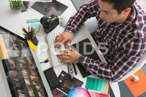 Male graphic designer working on computer at desk Stock Photos