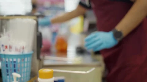 Male Grocery store worker doing checkout scanner for customer shopping cash 動画素材 334644858